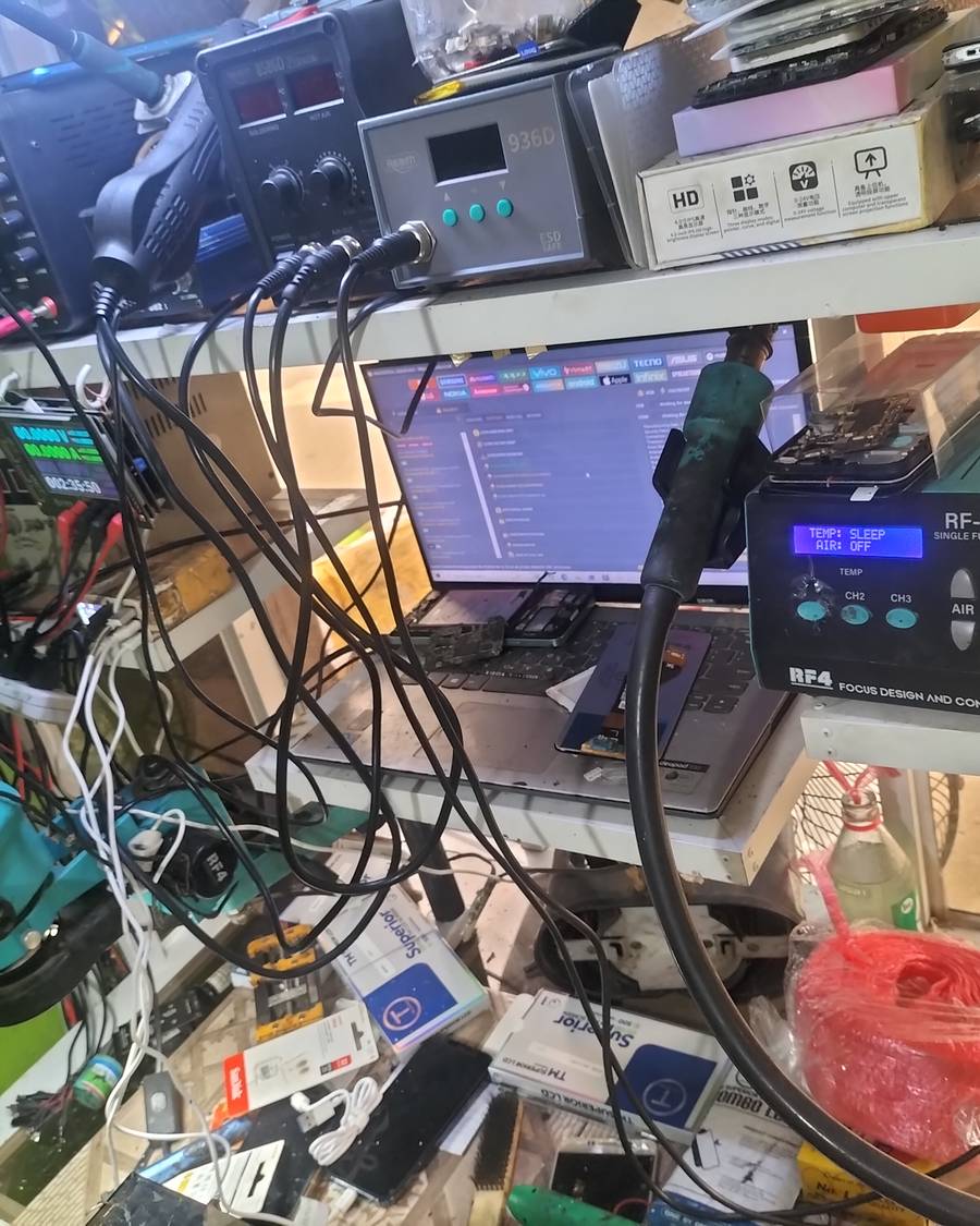 Wilfredo's phone repair workbench with diagnostic and micro-soldering tools